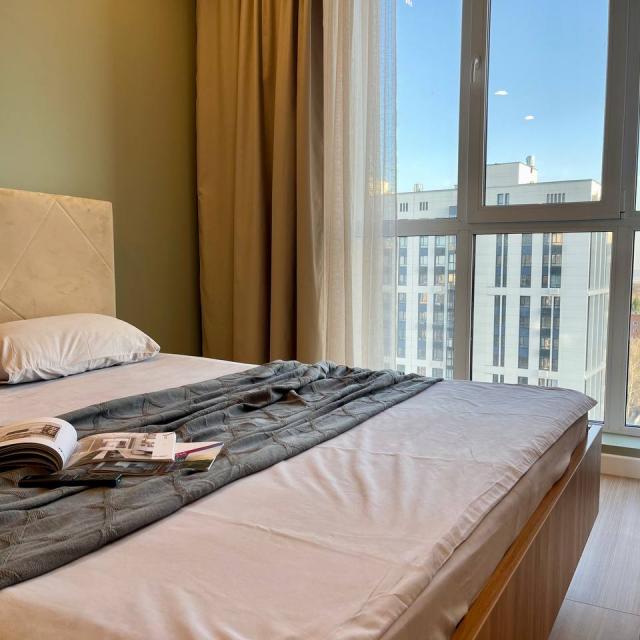New apartment with a bed near a panoramic window, high floor