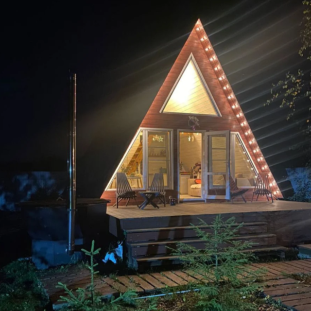 A-frame house with a bath tub and a wood-burning sauna